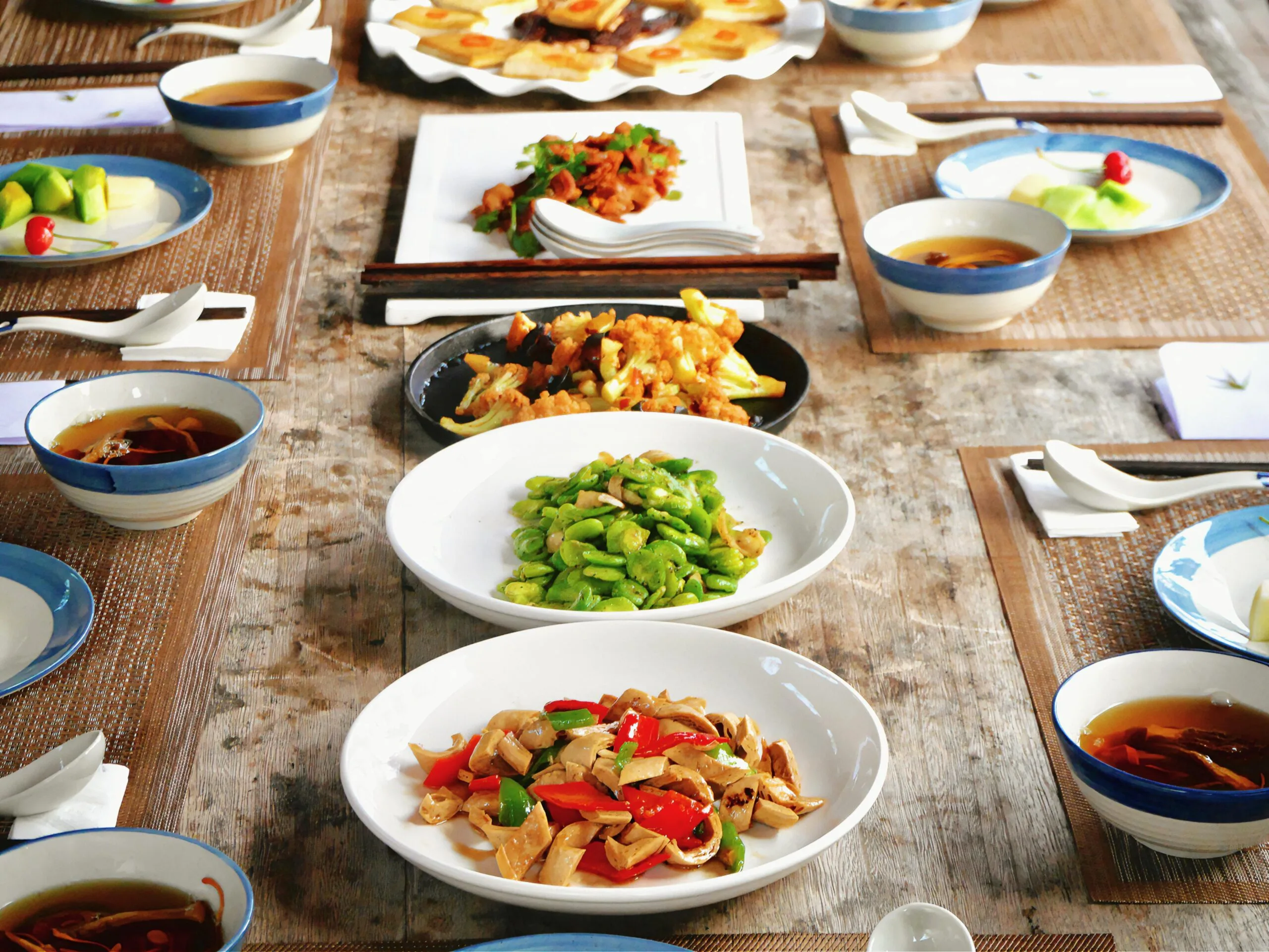 A beautifully arranged table with a variety of traditional Asian dishes.